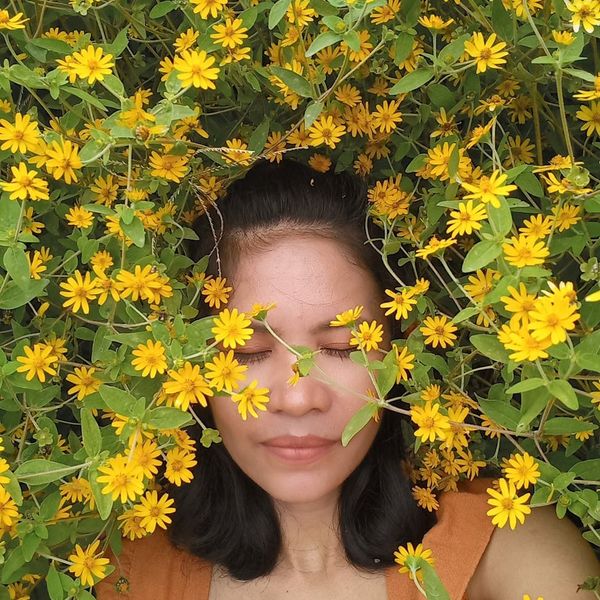 Person meditating outdoors, surrounded by nature and tranquility.